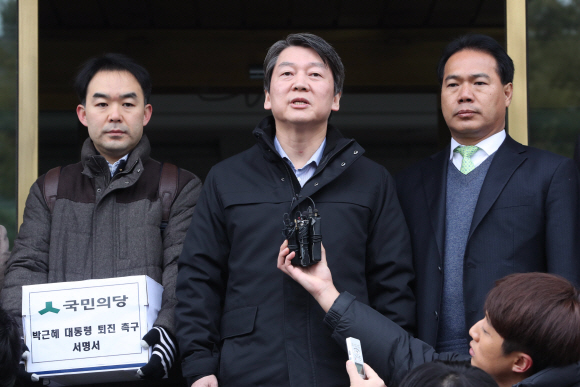국민의당 안철수 전 대표(가운데)가 12일 오전 ’박근혜 대통령 퇴진’을 요구하는 국민 21만명의 서명을 헌법재판소에 전달하기에 앞서 취재진의 질문에 답하고 있다. 이언탁 기자 utl@seoul.co.kr