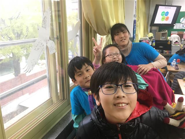 서울 관악구 초등학생들이 교실 유리창에 동물복지 실천을 다짐하는 내용의 조류 충돌방지 스티커를 붙이고 환하게 웃고 있다.<br>관악구 제공
