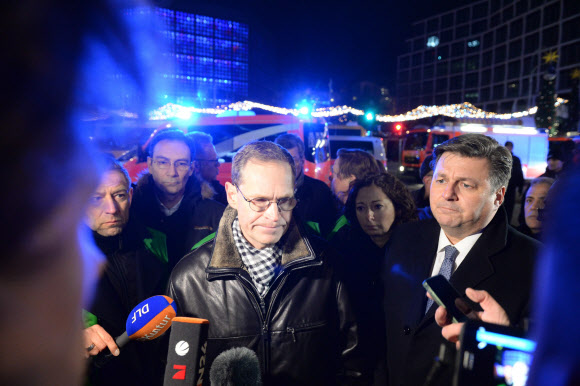 미카엘 뮐러(앞줄 왼쪽) 베를린 시장이 19일(현지시간) 트럭테러 현장에서 기자들에게 브리핑을 하고 있다. 폴란드에 차량 등록을 한 19t 스카니아 트럭이 시속 65㎞ 속도로 보도로 난입해 수십명의 사상자가 발생했다. EPA 연합뉴스