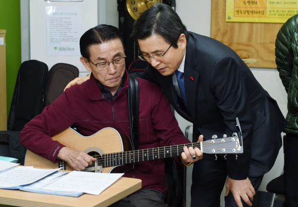 황교안(오른쪽) 대통령 권한대행이 23일 오후 서울 동작구 대방종합사회복지관을 찾아 통기타 강습반에서 어르신의 연주를 들으며 격려하고 있다. 안주영 기자 jya@seoul.co.kr