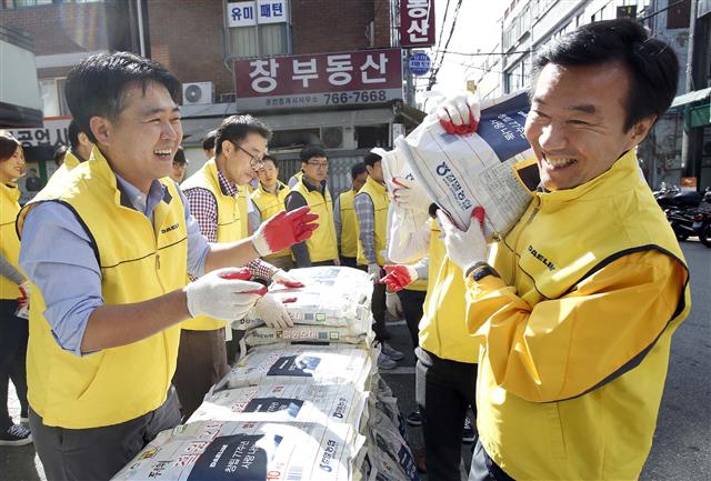 지난 10월 서울 종로구 창신2동에서 김한기(오른쪽) 대림산업 대표이사 등 직원 200여명이 저소득층 가정 쌀 배달봉사를 하고 있다. 대림산업 제공