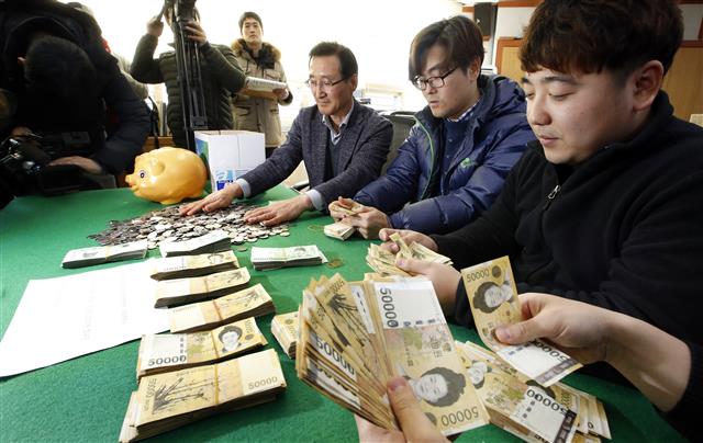 전주시 노송동주민센터 직원들이 28일 올해도 ‘얼굴 없는 천사’가 놓고 간 성금 5000여만원을 세고 있다. 노송동주민센터 제공