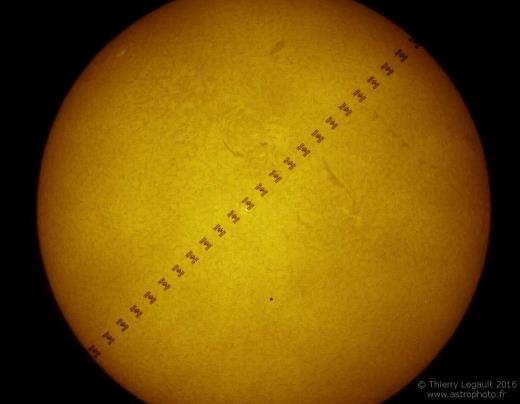 태양을 대각선으로 통과하는 국제우주정거장(ISS)의 합성 사진. 0.6초 사이에 통과하는 모습을 점으로 이었다. 태양 중간 하단에 위치한 작은 점은 수성이다. 미 항공우주국(NASA) 제공