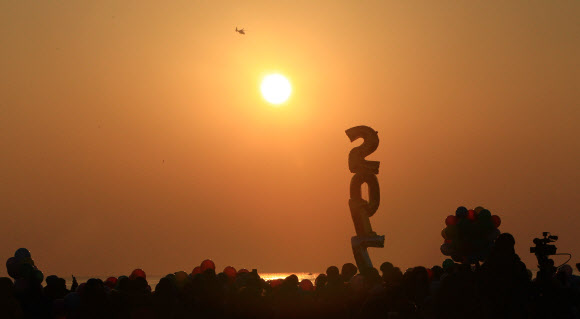 1일 새벽 속초해변을 찾은 관광객들이 풍선을 준비하고 해맞이를 하고 있다.  연합뉴스