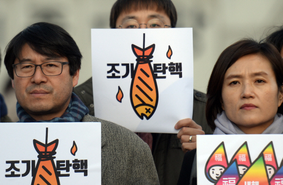 3일 서울 광화문광장에서 참여연대 회원들이 시무식을 갖고 정권을 비판하는 피켓을 들고 있다. 2017.1.3 박지환기자 popocar@seoul.co.kr