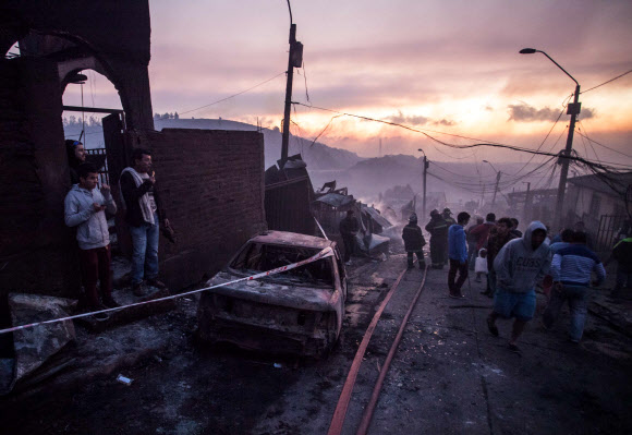 2일(현지시간) 칠레 중서부 항구도시 발파라이소 남부 교외 라구나 베르데 지역에서 화재가 발생해 주택 150채가 전소됐으며 19명이 부상했다. 사진은 주민들이 화재 현장에서 서성이는 모습. AFP 연합뉴스