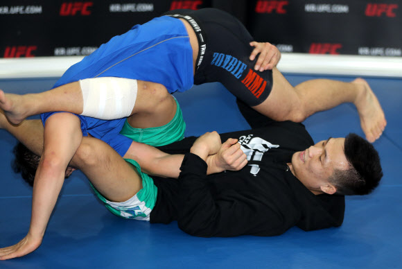 UFC파이터 정찬성이 4일 오후 서울 강남구 역삼동 코리안 좀비 종합격투기 체육관에서 열린 공개훈련 행사에서 그라운드 기술을 선보이고 있다. 연합뉴스