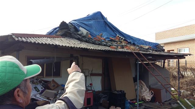 경주 지진의 진앙인 내남면 부지1리 김동희(57)씨가 자신의 피해 가옥을 가리키고 있다. 김씨는 경제적인 부담 등으로 골기와와 기와공을 구하지 못해 지진으로 파손된 한옥 지붕을 수리하지 못하고 있다고 말했다.