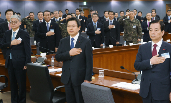 황교안(가운데) 대통령 권한대행이 4일 서울 종로구 정부서울청사 별관에서 열린 외교안보 부처 신년 업무보고에서 한민구(오른쪽) 국방부 장관, 윤덕민(왼쪽) 국립외교원장과 함께 국기에 대한 경례를 하고 있다. 안주영 기자 jya@seoul.co.kr