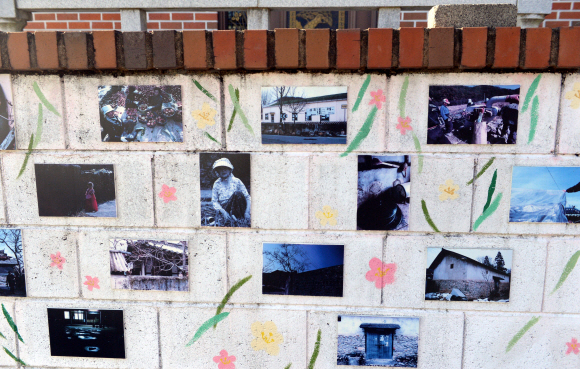 수몰 전 옛 마을을 기록한 사진들을 골목 담벼락에 전시하고 있다.