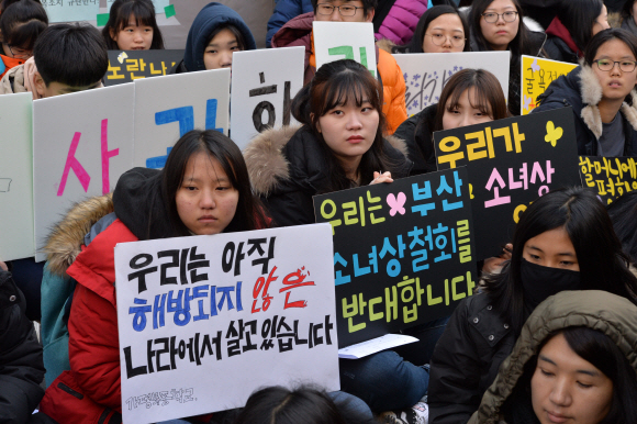 11일 서울 종로구 중학동 옛 주한일본대사관 앞에서 일본군 위안부 문제 해결을 위한 수요시위에 참석한 한 여중생이 부산 소녀상 철거 반대 문구가 적힌 피켓을 들고 있다. 한국과 일본은 부산 주한일본총영사관 앞에 설치된 소녀상을 두고 갈등을 겪고 있다. 2017. 1. 11 손형준 기자 boltagoo@seoul.co.kr