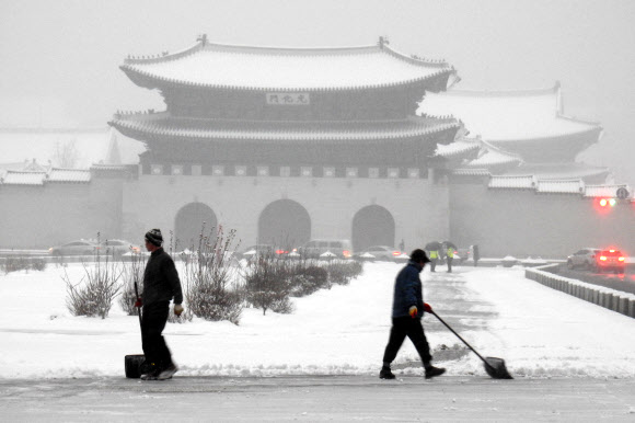 금요일이자 대한(大寒)인 20일 중부지방에 많은 눈이 내린 서울 광화문 광장에서 근무자들이 눈을 치우고 있다. 연합뉴스