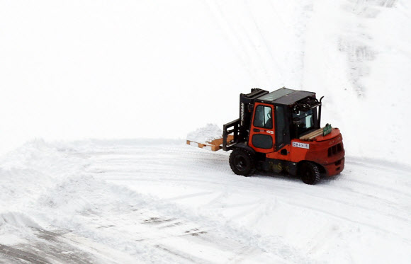 20일 오전 폭설이 내린 인천시 서구 정서진 인근 한 물류센터에서 지게차가 작업장에 쌓인 눈을 치우고 있다.  연합뉴스