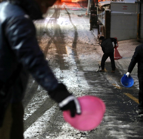 24절기상 대한(大寒)인 20일 오전 서울 선릉역 인근의 한 빌딩에서 관계자들이 신속히 제설 작업을 하고 있다.  연합뉴스