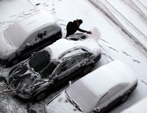 대한인 20일 경기도 전역에 대설주의보가 내린 가운데 출근 전 운전자가 간밤 차에 내린 눈을 치우고 있다.  연합뉴스