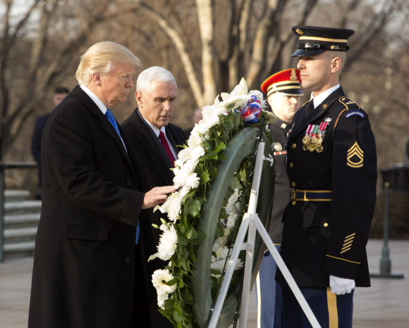 도널드 트럼프 미국 대통령 당선인(왼쪽)과 마이크 펜스 부통령 당선인이 19일(현지시간) 버지니아주 알링턴 국립묘지를 방문해 ‘무명용사의 묘’에 헌화하고 있다. EPA 연합뉴스
