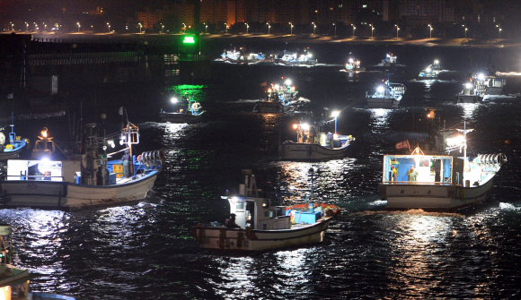 강원 강릉시 주문진항에서 새벽 3시 40분이 되자 불을 밝힌 어선들이 일제히 출항하고 있다.