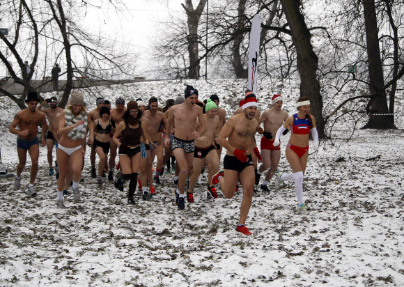 22일(현지시간) 세르비아의 수도 벨그라드에서 열린 ‘팬티만 입고 달리기(Underpants Run)’ 대회 참가자들이 눈덮힌 공원을 달리고 있다. AP 연합뉴스