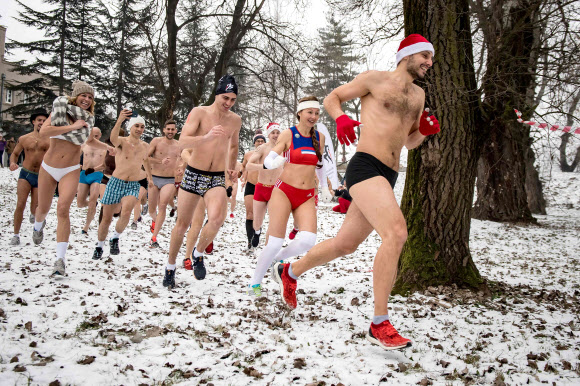 22일(현지시간) 세르비아의 수도 벨그라드에서 열린 ‘팬티만 입고 달리기(Underpants Run)’ 대회 참가자들이 눈덮힌 공원을 달리고 있다. AFP 연합뉴스