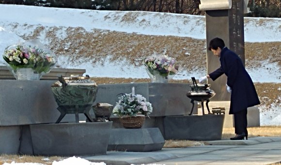 박근혜 대통령이 설 연휴를 앞둔 23일 오후 아버지인 박정희 전 대통령, 어머니인 육영수 여사의 묘소가 있는 서울 동작구 국립현충원을 찾아 성묘하고 있다. 청와대 제공