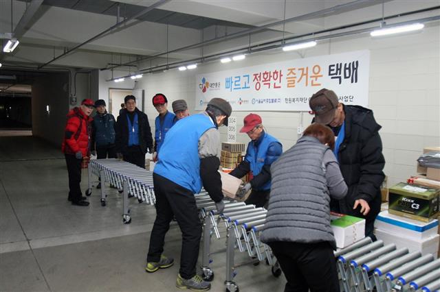 지난 24일 서울 구로구 천왕동의 한 아파트 단지 실버택배원들이 단지에 도착한 택배 물품들을 배송하기 위해 아파트 동별로 분류하는 작업을 하고 있다. CJ대한통운 제공