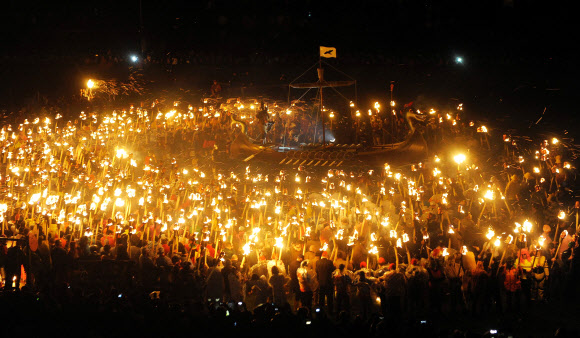 31일(현지시간) 스코틀랜드 셰틀랜드섬 러윅에서 ‘업 헬리 아 바이킹 축제(Up Helly Aa Viking festival)’가 열린 가운데 바이킹 복장을 한 참가자들이 횃불을 바이킹 배로 던질 준비를 하고 있다. AFP 연합뉴스