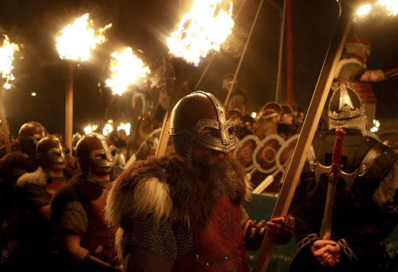 31일(현지시간) 스코틀랜드 셔틀랜드섬 러윅에서 ‘업 헬리 아 바이킹 축제(Up Helly Aa Viking festival)’가 열린 가운데 바이킹 복장을 한 참가자들이 횃불을 들고 축제를 즐기고 있다. AP 연합뉴스