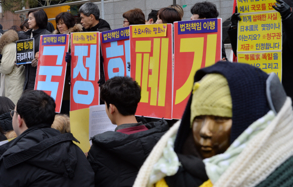 8일 서울 종로구 중학동 옛 주한일본대사관 앞에서 열린 1269차 일본군 위안부 문제 해결을 위한 수요시위 참석자들이 위안부 문제를 축소기술한 국정교과서 폐기를 촉구하는 손팻말을 들고 서 있다. 2017. 2. 8 손형준 기자 boltagoo@seoul.co.kr