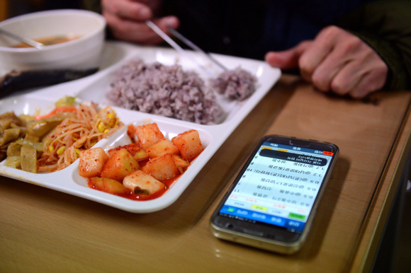 서울 광화문의 한 회사 구내식당에서 퀵서비스 기사 이모씨가 콜신호가 오는 휴대전화를 옆에 두고 혼자서 급하게 식사를 하고 있다. 정연호 기자 tpgod@seoul.co.kr