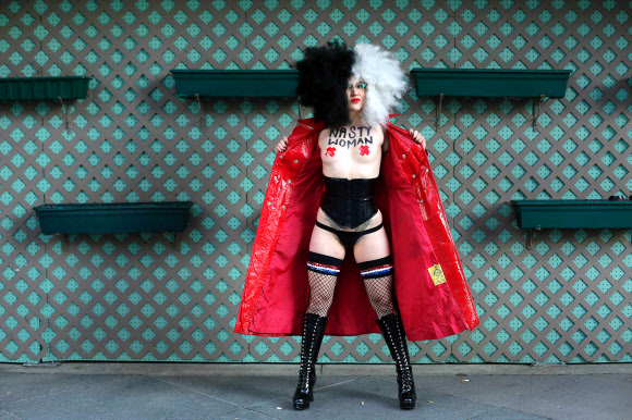 12일(현지시간) 미국 일리노이주 시카고의 트럼프 타워 인근에서 한 여성이 벌거벗은 채 트럼프 대통령의 정책에 반대하는 시위를 하고 있다. AFP 연합뉴스