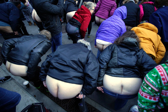 12일(현지시간) 미국 일리노이주 시카고의 트럼프 타워 인근에서 시위대들이 바지를 내리고 엉덩이를 내보이며 트럼프 대통령의 정책에 반대하는 시위를 하고 있다. AFP 연합뉴스