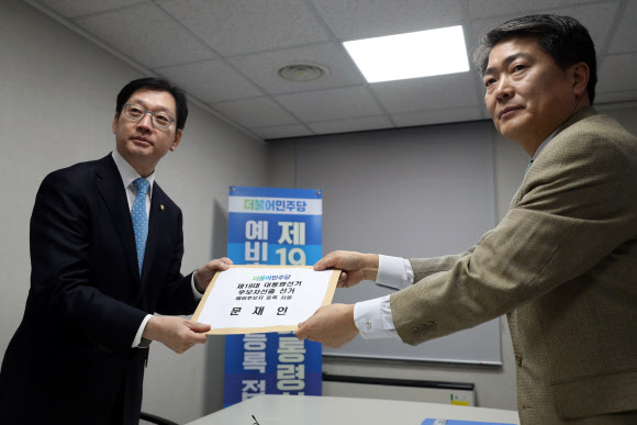 13일 오전 서울 여의도 더불어민주당 당사에서 문재인 전 대표의 대리인인 김경수 의원(왼쪽)이 문 전 대표의 대통령선거 후보 경선 등록 서류를 제출하고 있다.  연합뉴스