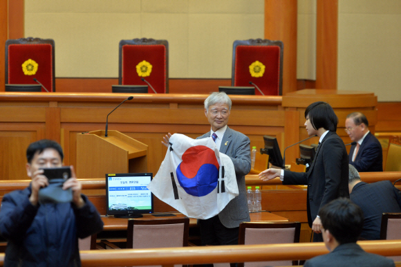 14일 오전 서울 종로구 재동 헌법재판소에서 열린 박근혜 대통령 탄핵심판 13차 변론에서 서석구 대통령 변호인이 태극기를 펼쳐보이다 직원에게 주의를 받고있다. 손형준 기자 boltagoo@seoul.co.kr