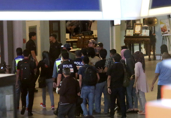 17일 말레이시아 쿠알라룸푸르 국제공항에서 경찰들이 셀프 체크인 기기 주변을 이동하며 김정남을 살해한 여성 용의자에 대해 범행 상황을 재연하는 현장 검증을 하고 있다. 쿠알라룸푸르 AP 연합뉴스