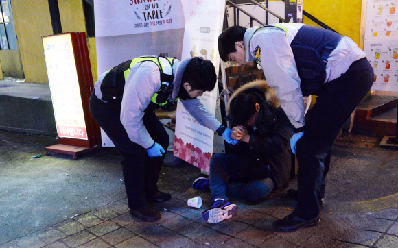 18일 새벽 시민의 신고를 받고 출동한 홍익지구대 소속 경찰들이 술에 취해 길거리에 쓰러져 있는 행인의 상태를 확인하고 있다. 손형준 기자 boltagoo@seoul.co.kr
