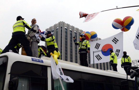 제98주년 3·1절인 1일 서울 광화문 광장에서 박근혜 대통령 탄핵 찬반 집회가 열린 가운데 반대집회 참가 시민 중 한명이 경찰 버스에 무단으로 오르자 찬성 집회 참가 시민들이 항의하고 있다.  박윤슬 기자 seul@seoul.co.kr