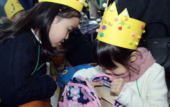 2일 서울 용산구 이태원초등학교에서 열린 입학식에서 한 신입생이 가방을 들여다보자 뒤에 앉은 친구가 함께 바라보고 있다. 박윤슬 기자 seul@seoul.co.kr