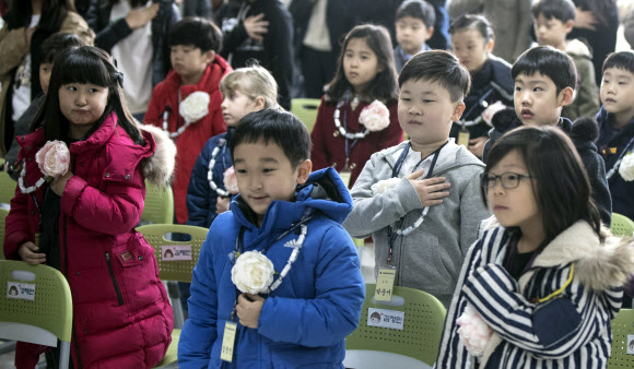 서울 용산구 용암초등학교에서 열린 2017학년도 초등학교 입학식에서 1학년 신입생을 비롯한 참석자들이 국기에 대한 경례를 하고 있다. 연합뉴스