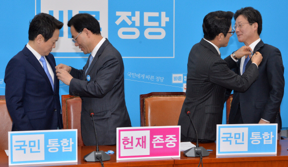 2일 국회에서 열린 바른정당 최고위원회의에서 정병국(왼쪽 세 번째) 대표와 주호영(왼쪽 두 번째) 원내대표가 당의 대선 주자인 유승민(맨 오른쪽) 의원과 남경필(맨 왼쪽) 경기지사의 옷깃에 ‘국민통합’ 배지를 달아주고 있다. 이종원 선임기자 jongwon@seoul.co.kr