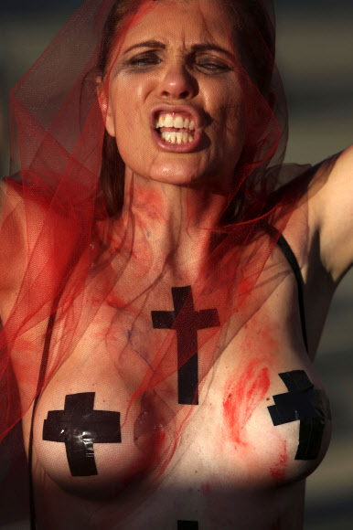 세계 여성의 날인 8일(현지시간) 브라질 브라질리아에서 한 여성이 자신의 몸에 가짜 피와 십자가를 그린 후 성 평등을 요구하는 시위를 하고 있다. AP 연합뉴스
