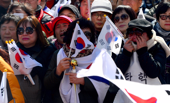 10일 헌법재판소 앞 안국역에서 보수단체 회원들이 탄핵이 인용되자 눈물을 흘리고 있다.  박지환 기자 popocar@seoul.co.kr