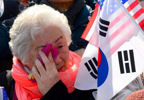 10일 헌법재판소 앞 안국역에서 보수단체 회원들이 탄핵이 인용되자 눈물을 흘리고 있다. 박지환 기자 popocar@seoul.co.kr