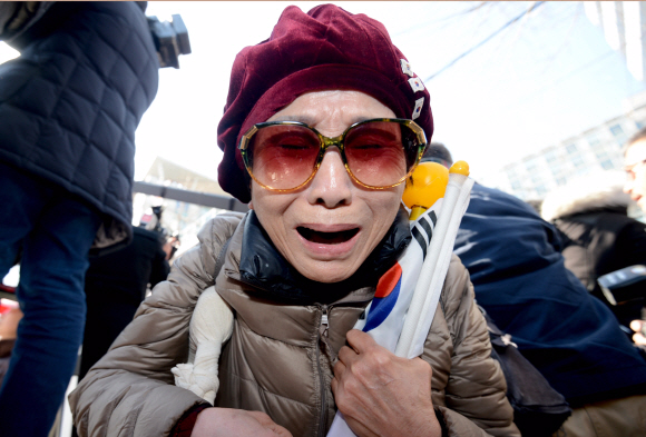 10일 서울 헌법재판소 앞 안국역에서 보수단체 회원이 탄핵이 인용되자 눈물을 흘리고 있다. 박지환 기자 popocar@seoul.co.kr