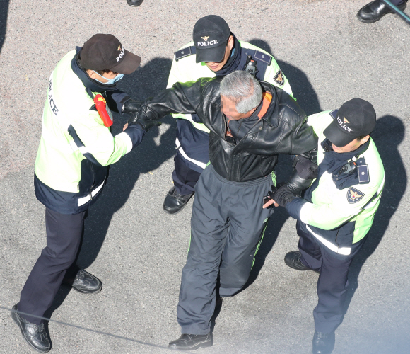 14일 오후 서울 강남구 삼성동 박근혜 전 대통령 자택 앞에서 경계를 서고 있는 경찰들에 항의하던 남성이 경찰에 제지당하고 있다.  사진공동취재단