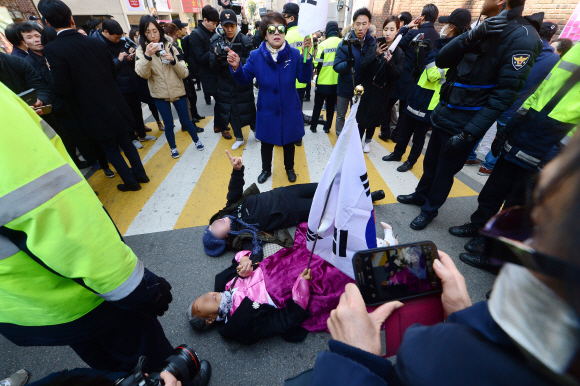 14일 서울 삼성동 박근혜 전 대통령 자택 앞에서 박근혜 전 대통령 지지자들이 도로에 누워 언론차 취재차량의 통행을 방해하고 있다. 정연호 기자 tpgod@seoul.co.kr