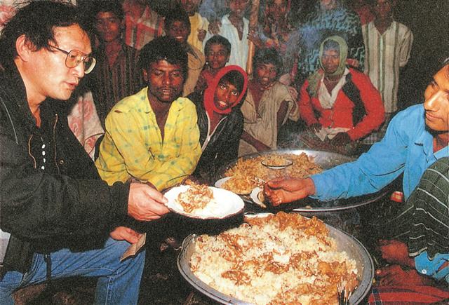 방글라데시 다카에서 주민들과 함께 음식을 먹고 있는 저자. 메멘토 제공