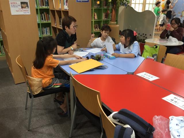 강서진로주치의(강진주)가 화곡1동 주민센터를 찾은 학생들에게 진로 상담을 해주고 있다.<br>강서구 제공