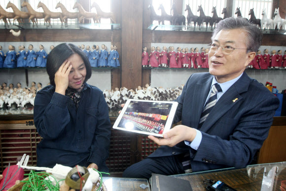 더불어민주당 문재인 전 대표가 23일 전북 전주시 완산구 한옥마을의 공예공방촌을 방문해 한지 공예가 양미영씨와 이야기를 나누고 있다. 전주 연합뉴스