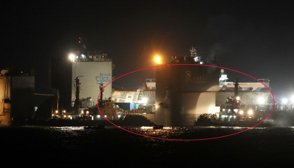 24일 오후 세월호(빨간선 뒷 부분)가 반잠수식 선박에 도착, 선적작업을 하고 있다.  연합뉴스