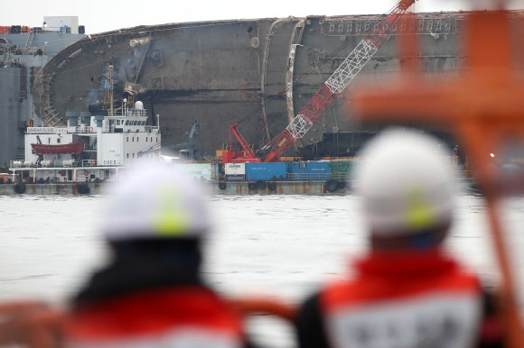 26일 오전 전남 진도군 세월호 사고 해역 부근에 정박중인 반잠수식 선박 화이트마린호 인근에서 해경 관계자들이 선적된 세월호를 바라보고 있다. 연합뉴스